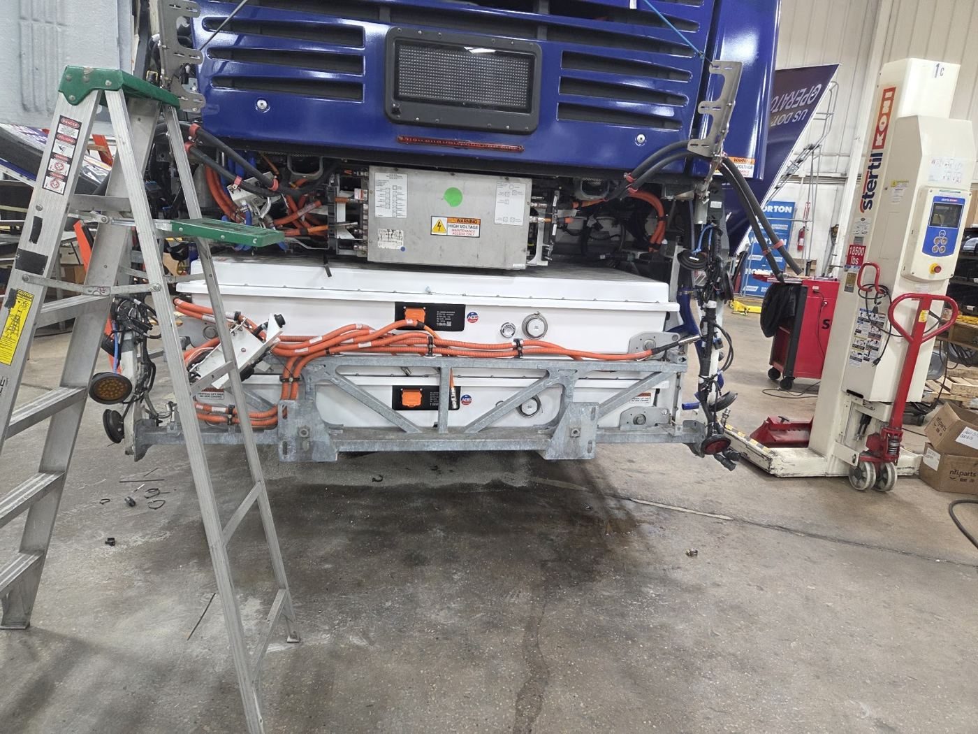 Frontal de un autobús urbano abierto en un elevador para trabajos en el sistema de alta tensión