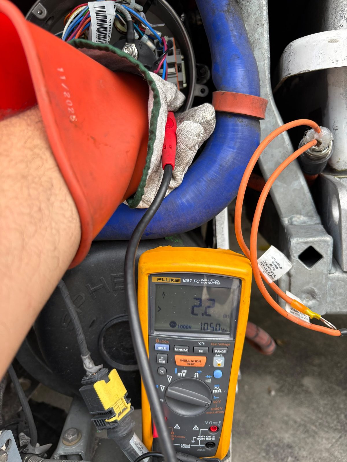 Técnico con guantes de alta tensión homologados midiendo el aislamiento con un Fluke 1587 FC que marca 2,2 gigaohmios a 1000 voltios