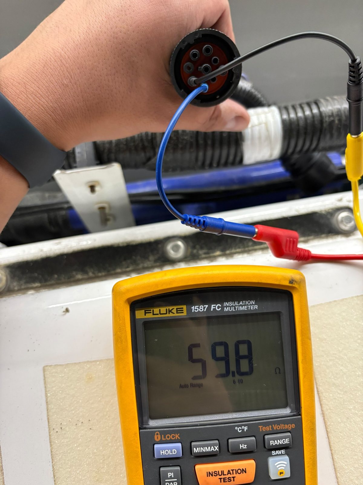 Polímetro marcando 59,8 ohmios entre CAN alto y CAN bajo en un conector de diagnóstico de 9 pines